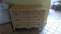 Front view showing serpentine three-drawer configuration and carved floral details