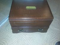 Closed wood presentation case with brass plaque on lid