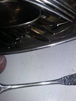 Close-up of stacked spoons and forks inside oval tray