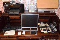 Full view of all office electronics on wooden desk including Sony monitor, HP printer, Panasonic DVD/VHS player, VTech phone system, and audio monitor