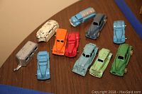 Overview of all toy cars and trailers arranged on a table showing variety of colors and wear