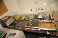 Wide shot of collection of vinyl records on table showing multiple swing era boxed sets and classical albums.