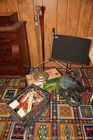 Full lot overview showing music stand, vintage fan, crate with cords, and box for sprinkler.