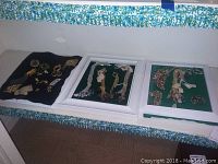 Full view of costume jewelry assortment including three trays with pins, brooches, and earrings arranged on black felt and green backdrops.