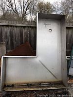Full view of the stainless steel commercial sink unit positioned outdoors, showing the overall shape and size.