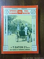 Front cover of the Eatons Catalogue reproduction showing vintage car and couple illustration with orange border and title text.