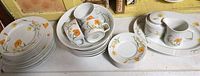 Photo showing grouped Jardin dinnerware items including stacked plates, cups, saucers, cream and sugar set