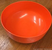 Top angled view of the orange Rosti Denmark bowl showing smooth interior and round shape.