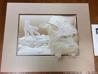 Photo of the unframed signed and numbered print depicting sculptural animal imagery with a detailed wolf head, on beige matte, on wood surface.