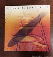 Closed box case showing Led Zeppelin logo on wood grain design