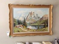 Full view of framed oil painting featuring mountain landscape with cabin and lake