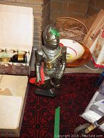 Plaster knight statue in armor, standing on a base, approximately 2 feet tall, with red details.