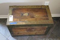 Top down view of vintage wooden chest showing wood grain and metal trim with some wear.