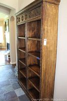 Full view of the tall wooden bookcase showing shelves and side profile.