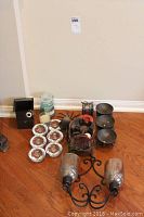 Full view showing assorted candle holders including glass votive holders, metal holders, and candles.