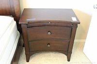 Front view of night stand with both drawers closed, showing dark wood finish and drawer knobs.