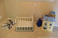 Photo showing the vintage metal doll baby bed with mattress and dollhouse with furniture packed in blue bag.