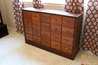 Full front view of oak filing chest showing 20 drawer faces with metal label-holder pulls