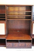Full front view of the solid wood center bookcase unit showing three shelves on top and four drawers at the bottom under a TV console space.