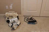 Wide view showing both Singer sewing machines along with extension cords on carpeted floor.