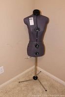 Full view of gray adjustable dress form on metal tripod stand showing adjustment dials and overall condition.