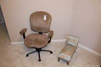 Full view of tan velour fabric rolling desk chair and miniature doll chaise lounge with floral upholstery.