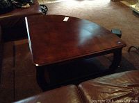 Top and side angle of dark wood square coffee table with rounded corners and thick legs, showing overall design and condition.