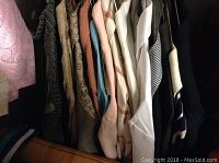 Hanger view showing 15 leisure suits in various colors and patterns including white, brown, checked, and solid colors.
