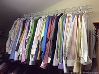 Full view of hanging dress shirts showing a variety of colors and styles, hung on a wire rack.
