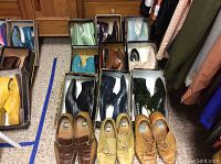 Overview of 12 pairs of men's dress shoes in boxes showing variety of colors including yellow, turquoise, brown, black, beige, green