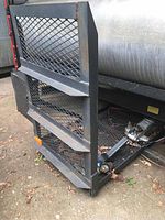 Side view showing the iron rack's mesh platform, reinforced sides with horizontal bars, and mounting mechanism.