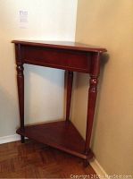 Side and front view of the wooden corner table showing its triangular shape, turned legs, and lower shelf.