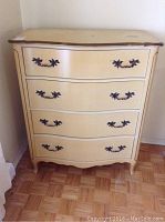 Full front view of yellow painted Kroehler dresser with four drawers and dark ornate handles.