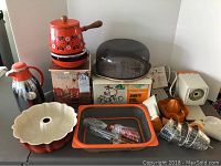 Photo showing the overall set including coffee pot thermos, fondue pot, cake dome, juicer box and various kitchen items.