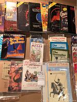 Assorted role-playing and wargaming booklets arranged on cardboard backdrop, front view