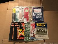 Photo of assorted Wargamer and Wargamers Digest magazines arranged on cardboard, showing multiple issues with various covers including red, black, white, and green.