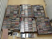 Wide view of stacked music CDs in cardboard boxes showing overall volume and condition