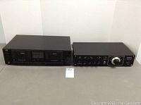 Front view of JVC TD-W503 cassette deck and Advent Model 300 stereo receiver side by side on table against white background.