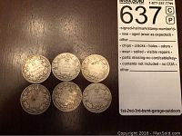 Overview of six Canadian 25 cent coins laid out on dark surface.