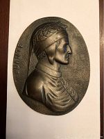 Front view of the oval copper bronze plaque showing a detailed profile bust of Dante Alighieri with laurel wreath. Marked "DANTE" on left edge.