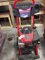 Front view showing red frame, control panel, and Briggs & Stratton engine on Troy Bilt pressure washer