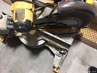 Side view of saw mounted on aluminum base showing cord and blade guard.