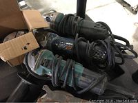 Three electric hand grinders stacked showing cords and metal guards, all used condition.