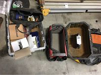 View of open tool pouches and bags with various tools inside placed on the floor