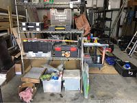 Wide view of full metal shelving unit showing various bins, toolboxes, and insulation items on shelves and floor beneath