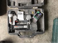 Top view of a Porter Cable nailer inside black molded plastic carrying case with additional nails and accessories.