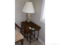 Vintage wooden drop leaf table with chair and ceramic lamp on top