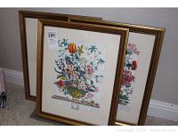 Three floral framed prints arranged, showing front view of three gold-tone frames with floral artwork