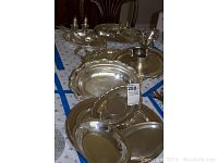 Photo showing multiple silver plate trays and bowls stacked and arranged on a table.