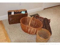 Five brown woven baskets of different sizes and shapes displayed on carpet and hardwood flooring.